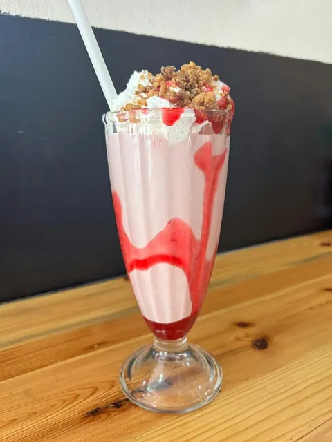 Berry Bliss shake topped with cream, berry syrup and a strawberry.
