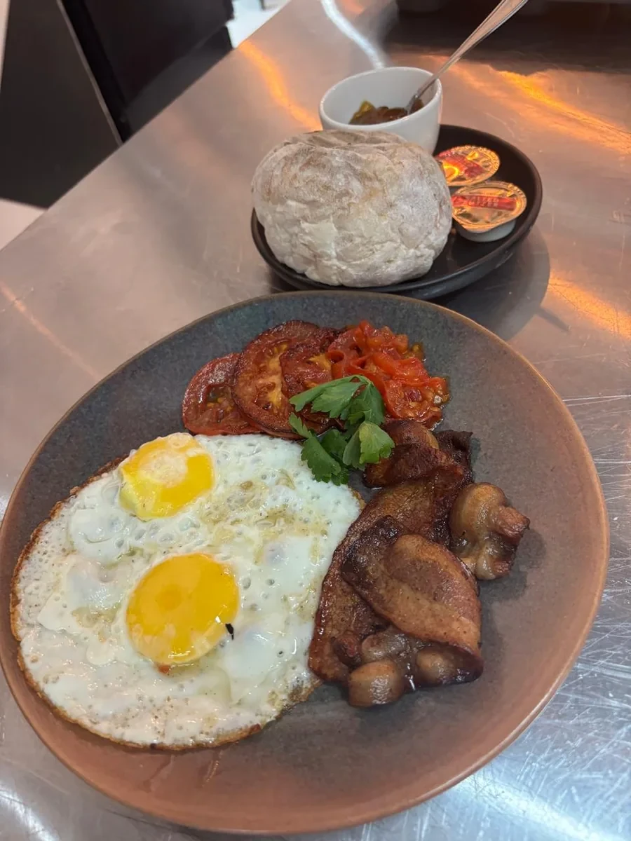 House breakfast with eggs, bacon, grilled tomato and rooster brood at Salt & Roost in Hout Bay.
