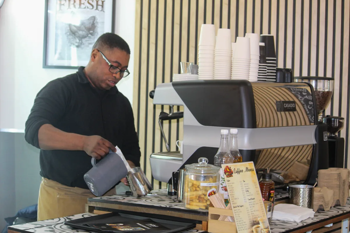 A Salt & Roost barista preparing coffee at the espresso machine.