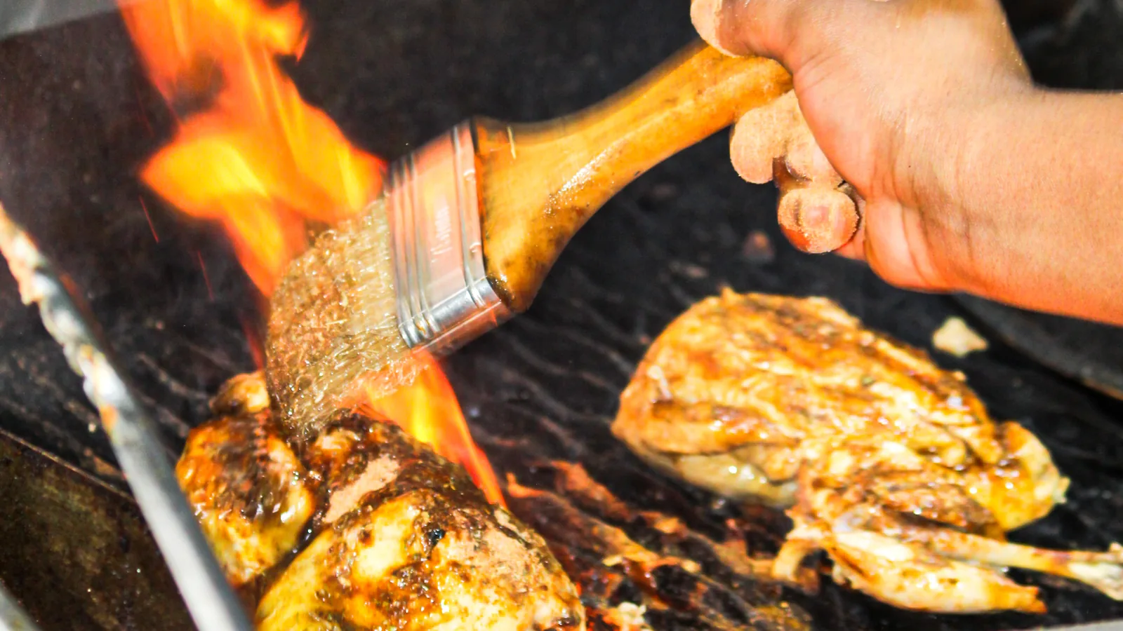 Chicken being basted over open flame at Salt & Roost.