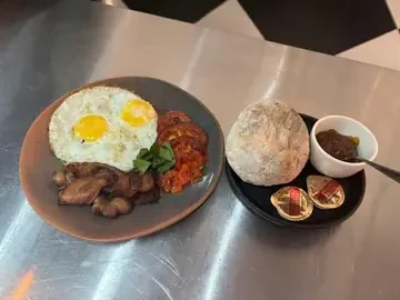 House Breakfast: fried eggs, bacon, grilled tomato and rooster brood with butter and jam.