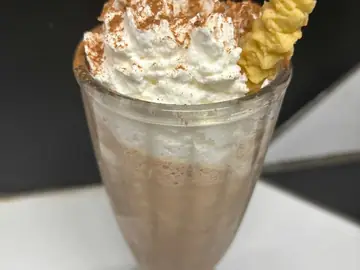 Cinnamon Swirl shake topped with cream, cinnamon dust and a biscuit.